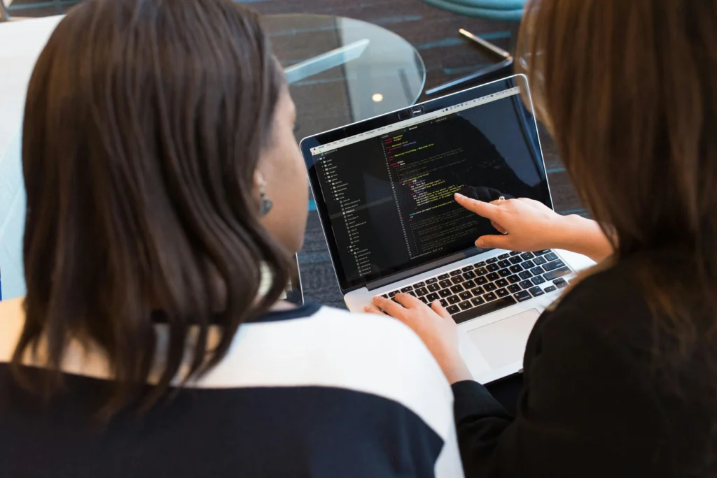 Dos mujeres trabajan en conjunto en su empleo tecnológico