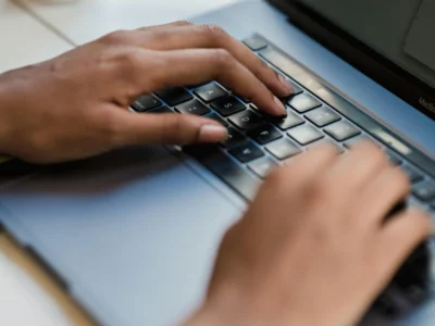 Manos de un hombre escribiendo y trabajando en marketing digital en una computadora portátil"
