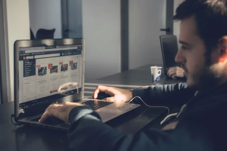 Hombre trabajando en su computadora portátil, redactando su currículum vitae con concentración en Cuba
